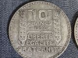 several coins of different shapes and sizes are on a blue cloth