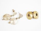 two pairs of gold and silver earrings on a white surface