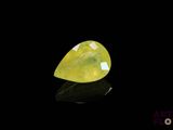 un gros plan d'un quartz jaune posé sur une surface noire