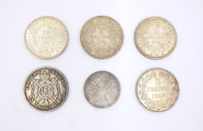six different british coins are arranged in a row on a white surface