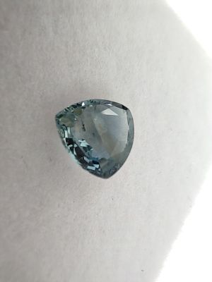 a close up of a blue diamond on a white surface