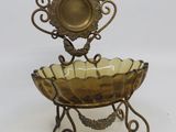 a metal stand with a glass bowl on top of it