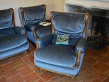 three blue chairs in a living room with a fire place