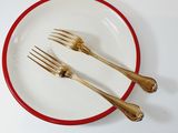 two forks and two spoons on a white plate