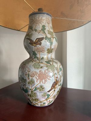 a lamp that is sitting on a table with a bird on it