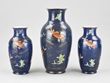 three vases that have fish on them on a table