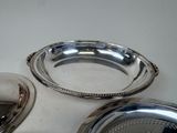 a silver plate and a silver bowl on a table