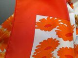 an orange and white dress with orange flowers on it