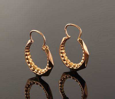 gold plated hoop earrings on a reflective surface