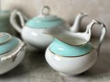 three teapots sitting on a table with a tea pot in the background