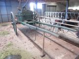 a horse drawn cart in a barn with a cow in the background