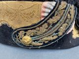 a black hat with a gold and black feather on it