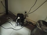 a black and white device sitting on the floor next to a fan