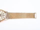 an image of a gold wrist watch with a white face