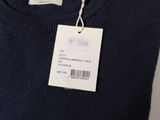 a close up of a blue sweater with a tag on it