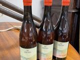 three bottles of wine sitting on a table next to a lamp