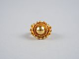 gros plan d'une bague en or sur une surface blanche