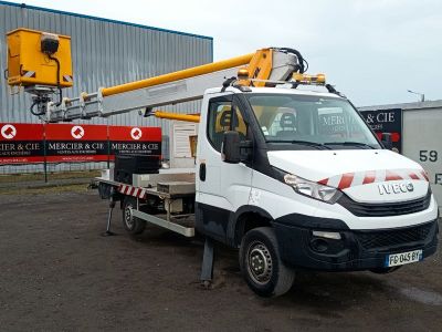 un camion équipé d'une grue à l'arrière, garé devant un immeuble
