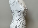 a white mannequin with black and white drawings on it