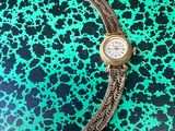 an image of a wrist watch on a green and black background