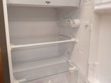 a white refrigerator with its door open in a kitchen