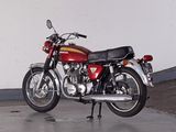 a red motorcycle parked in a garage with a white wall