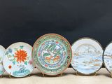 six assiettes aux motifs variés sont alignées sur une table