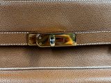 a brown leather purse with a gold metal clasp