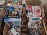 Plusieurs cartons de jouets sont posés sur une palette devant une fenêtre.