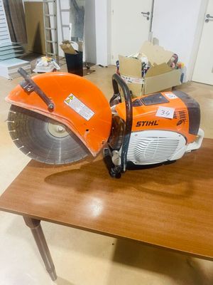 an orange and black circular saw on a wooden table