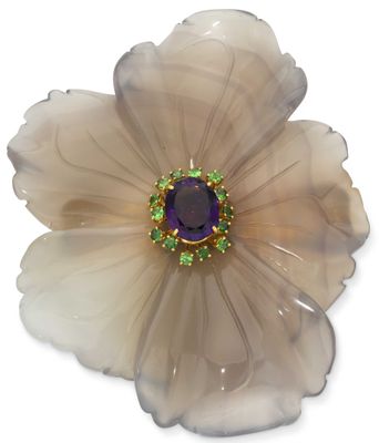 flower shaped brooch with purple and green stones on white background