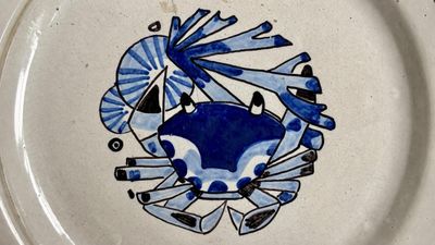 a blue and white plate with a crab on it