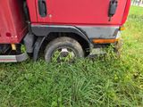 a red truck that is parked in the grass