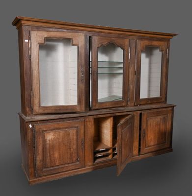 un vieux vaisselier en bois avec des portes vitrées et des étagères