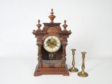 a small wooden clock and a candle holder on a table