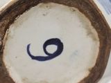a close up of a blue and white vase with a number on it