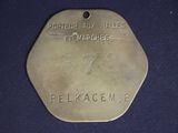 an old brass medal with the name of a man on it