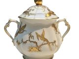 a white and gold teapot with a bird on it