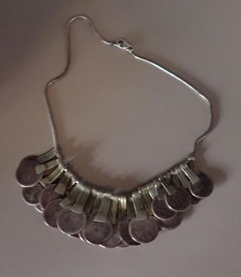 collier composé de pièces d'argent sur fond blanc