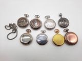 une sélection de montres de poche de différents types posées sur un fond blanc