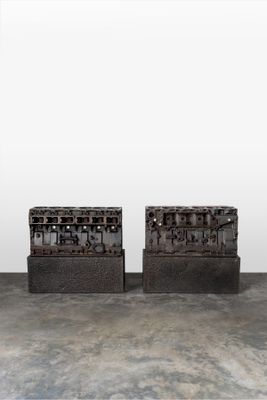 pair of black brick boxes on concrete floor with white wall