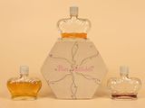 trois flacons de parfum posés l'un à côté de l'autre sur une table