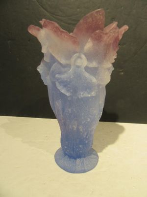 a blue vase with a pink flower in it on a table