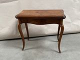 a small table with a wooden top on a cement floor