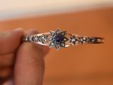 a person holding a ring with a flower design on it