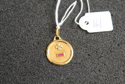 une médaille d'or suspendue à un cordon, avec une étiquette indiquant son prix