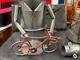 a metal sculpture of a man on a bike next to a lamp