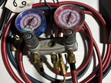 two gauges and a couple of hoses sitting on a table