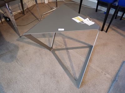 une table posée à même le sol, avec un plateau en verre