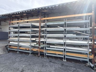 une grande pile de tuyaux métalliques devant un immeuble